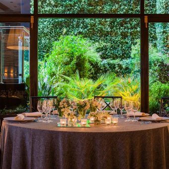 Montaje de una mesa en el salón de bodas con el jardín vertical de fondo